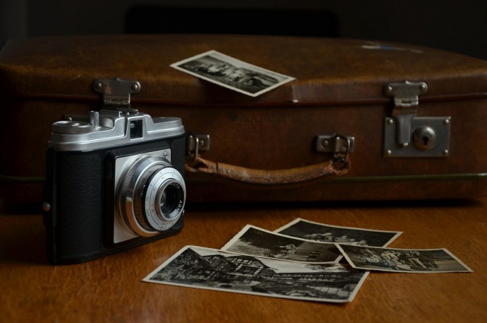 Old optical camera alongside photo prints